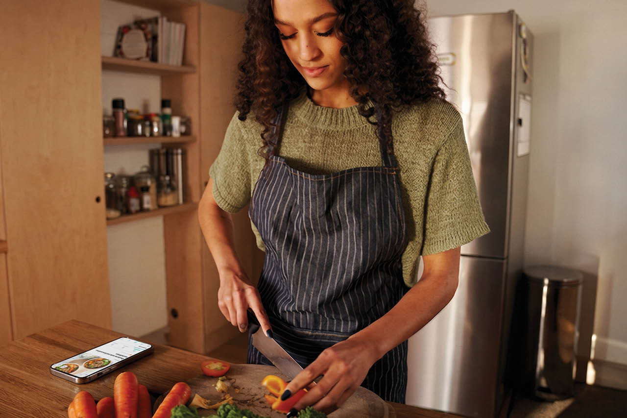 Vrouw kookt met Xtra-app open